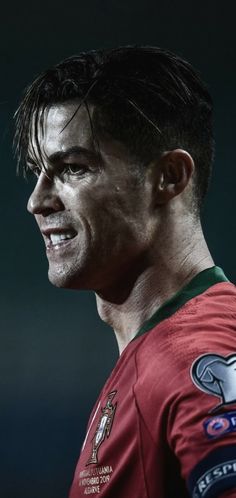 a close up of a soccer player wearing a red uniform and smiling at the camera