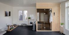 a room with a sauna and some benches in it next to two large windows