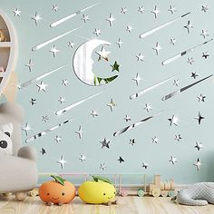 a child's room with stars and moon decals on the wall, including toys