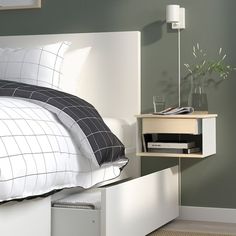 a bed with a white headboard and nightstand next to it