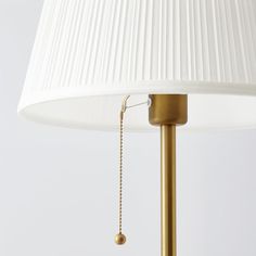 a white lamp with a gold chain hanging from it