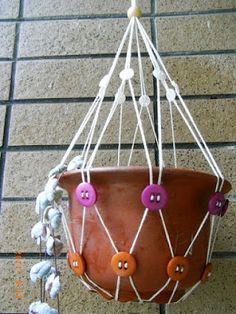 a potted plant hanging from a wire with buttons on the bottom and two strings attached to it