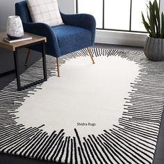 a white rug with black and white lines on it next to a blue chair in front of a window