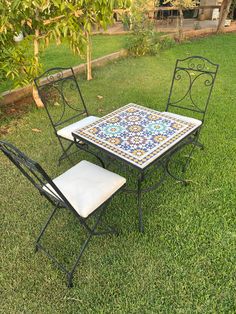 a table and two chairs sitting in the grass