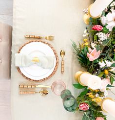 the table is set with white plates and goldware