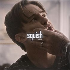 a man holding the word squish over his face to show it's meaning