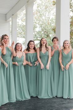 a group of women in green dresses posing for the camera