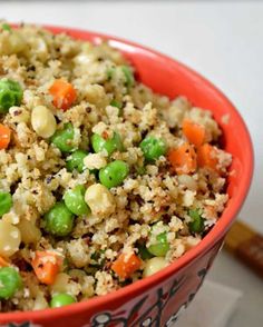 a red bowl filled with rice and vegetables