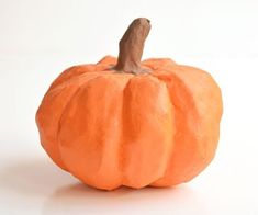 an orange pumpkin sitting on top of a white table