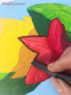 someone is painting a flower on a piece of paper