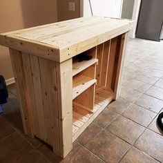 a kitchen island made out of pallets and wooden planks in the middle of a tile floor