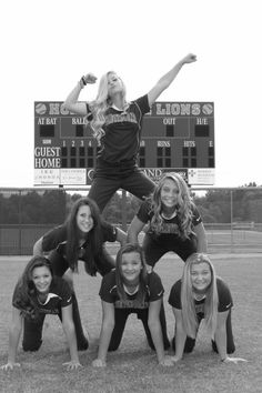 a group of young women standing on top of a baseball field