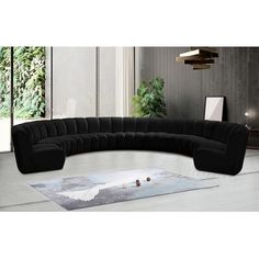 a large black sectional sofa sitting on top of a white rug in a living room