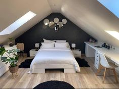 an attic bedroom with white furniture and black walls