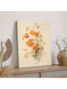 an orange and white flower painting on a shelf next to vases with dried flowers