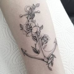 a black and white photo of an anchor with roses on the inside of its arm