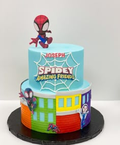 a spiderman themed birthday cake on a black plate