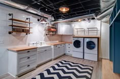 a laundry room with washer, dryer and shelves on the wall next to it