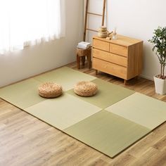 a room with wooden flooring and two round pillows on the floor next to a window