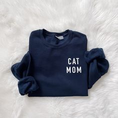 For all the Cat Mama's out there!  Cat Mom Sweatshirt, Cat Mama, Fur Mom Pullover, Cat Lovers Shirt, Cat Lovers Apparel Runs slightly larger / if you want an oversized feel, keep your regular size. 50% cotton, 50% polyester Adult Unisex sizing  Concealed seam on cuffs Seamless body Double-needle coverseaming on neck, armholes and waistband 1x1 ribbed collar, cuffs and waistband with spandex Recommended Care Instructions Machine wash delicate cycle, cold/warm, inside out with like colors. Do not bleach. Remove immediately after washing. Tumble dry on low or hang dry. Do not iron decal. Do not dry clean. Cat Mom Sweatshirt, Cat Mama, Fur Mom, Cat Mom Shirts, Cat Lover Shirt, Mama Cat, Womens Sweatshirts, Greensboro Nc, Mom Sweatshirt