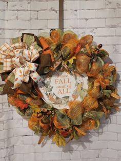 a fall wreath hanging on a brick wall