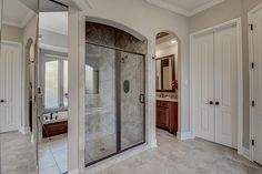 a large bathroom with a walk in shower next to a double sink vanity and toilet