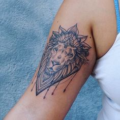 a woman's arm with a lion tattoo on the left side of her arm