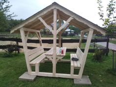 a wooden picnic table and bench in the grass