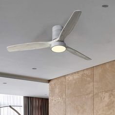 a ceiling fan mounted on the side of a wall next to a bed in a bedroom