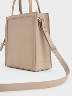 This product is made with at least 20% sustainable materials by weight. CHARLES & KEITH uses recycled, degradable, organic, and water-based materials in our eco-conscious collection. If you prefer a lighter and softer alternative to black, this neutral-toned tote bag in taupe is just as versatile. It features a structured and angular silhouette that is a perfect blend of form and function. Opening up to a spacious interior, it will be able to hold everything you need in a day with ease. Carry yours by the double top handles or attach the adjustable strap to turn it into a shoulder bag. Taupe Colour, Charts For Kids, Size Chart For Kids, Charles Keith, Printables Kids, Neutral Tones, Belt Size, Comfortable Shoes, Latest Fashion