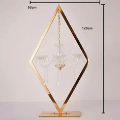 a golden diamond shaped chandelier with crystal drops hanging from it's sides