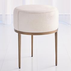 a round stool with wooden legs and a white upholstered cushion on the top