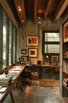 an office with lots of books on the shelves and desks in front of large windows