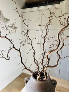 a vase with branches in it sitting on a table next to a star shaped decoration