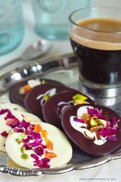 some kind of appetizers on a silver plate next to a cup of coffee