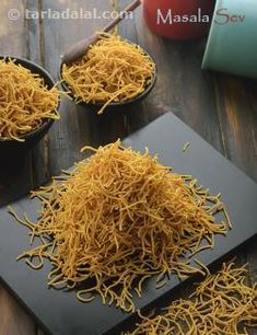 two bowls filled with yellow noodles on top of a wooden table