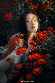 a woman with long black hair holding red flowers