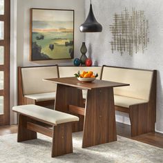 a dining room table with two benches and a bowl of fruit on the table next to it