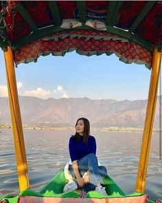 a woman sitting on top of a boat in the water