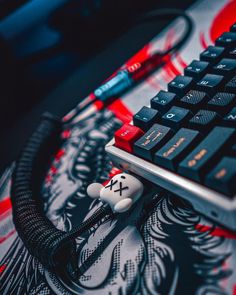 a close up of a computer keyboard with a skull keychain on the keys