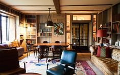 a living room filled with furniture and bookshelves next to a dining room table