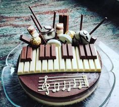 a chocolate cake decorated with musical instruments and music notes on it's top layer