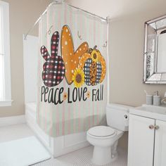 a bathroom with a shower curtain that says peace love fall