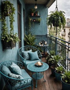 the balcony is decorated with potted plants and wicker furniture, including two blue chairs