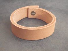 This beautiful leather bracelet was made using high quality leather and will wear wonderfully with age. The leather cuff is provided with a strong silvery rivet, for a quick and easy closure.Guidelines : ● wide: 1.7 cm (0.7")● long: 17 cm (6.7") long (from a snap to another) -> It would best fit a 15 cm (6") wrist. ● thick: 3 mmIt will definitely add a sweet touch to your outfit! *** It will be packed in a linen bag, hand stamped with a black arrow that would make a pretty keepsake. *** For more Beige Leather Jewelry, Bracelet For Her, Womens Bracelet, Black Arrow, Bracelet Leather, Linen Bag, Leather Key, Leather Keychain, Leather Cuffs