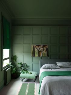 a bedroom with green walls and white bedding in front of a window that reads, farrow & ball surround yourself in tasting color with new, multi - surface dead flat