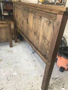 a bed frame made out of wood in a room with other items on the floor