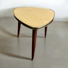 a small wooden table sitting on top of a cement floor