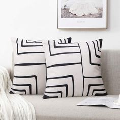 three black and white pillows sitting on top of a couch