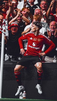 a man sitting on top of a soccer field in front of a group of people